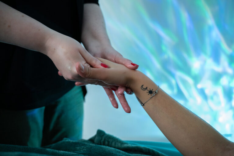 Séance de Headspa avec massage de la main, zoom sur le geste relaxant réalisé par la praticienne en pleine séance de bien-être.